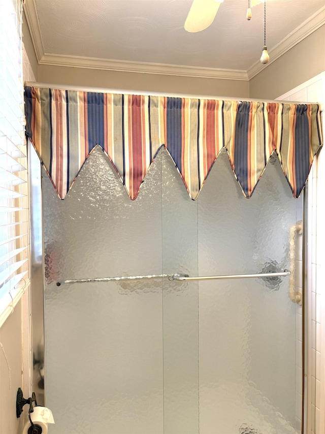 bathroom with crown molding and a shower with shower door