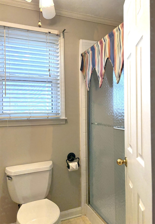 bathroom featuring ornamental molding, toilet, and walk in shower