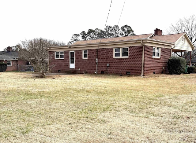 rear view of property featuring a lawn