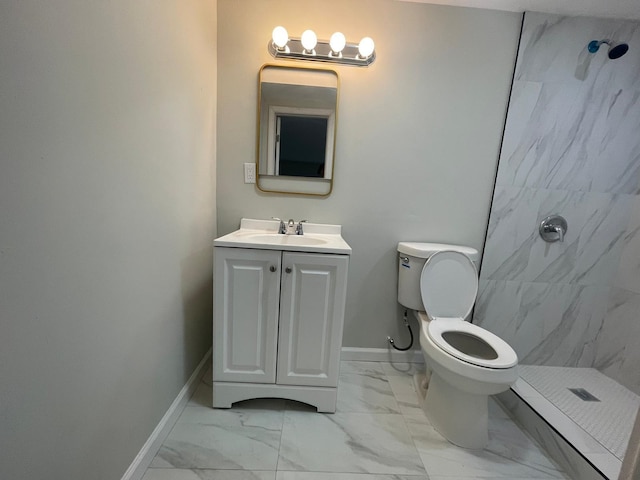 bathroom with vanity, tiled shower, and toilet