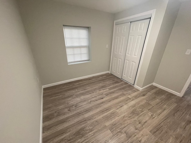 unfurnished bedroom featuring wood-type flooring and a closet