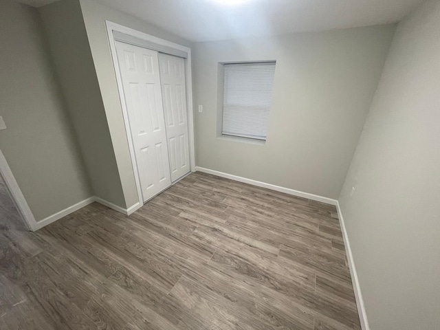 unfurnished bedroom with hardwood / wood-style flooring and a closet