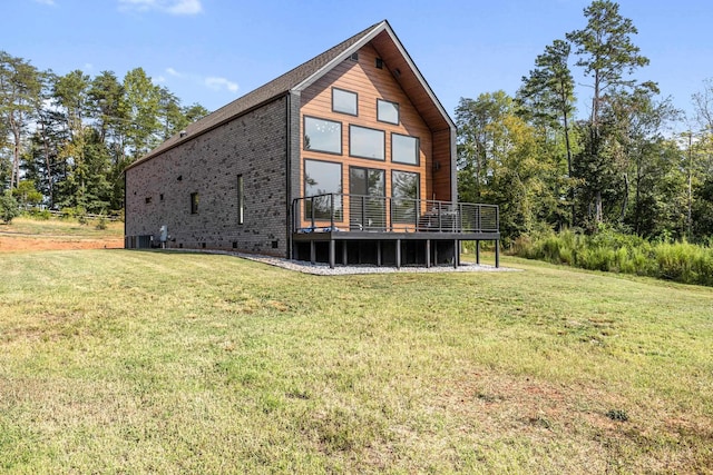 back of house with central AC, a deck, and a lawn