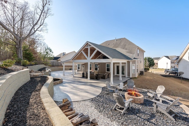 rear view of property with cooling unit, a patio area, and an outdoor fire pit