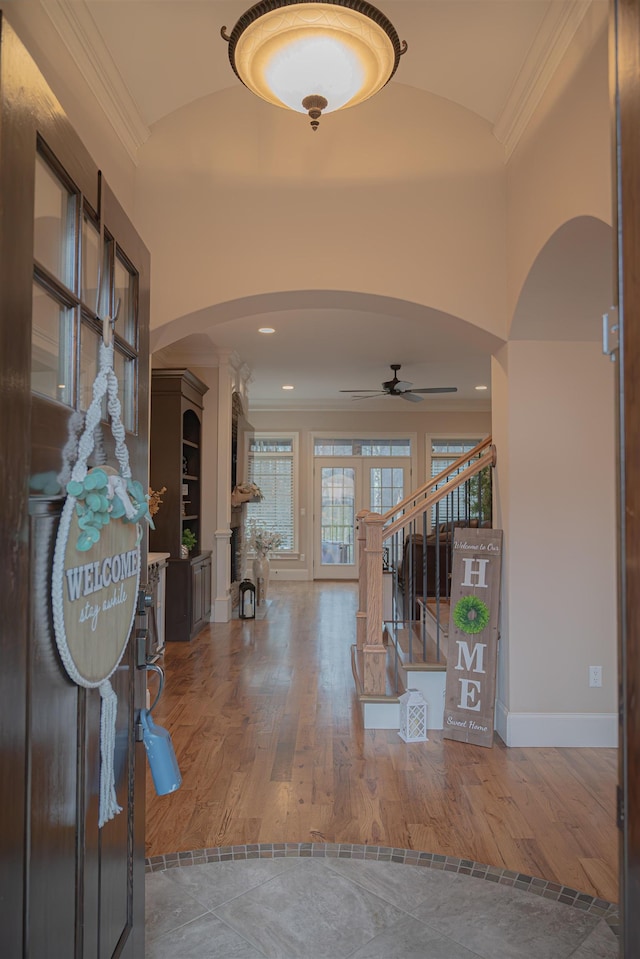 entryway with ornamental molding, vaulted ceiling, and wood-type flooring