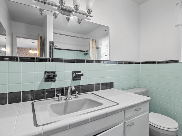 bathroom with a shower with curtain, vanity, toilet, and tile walls