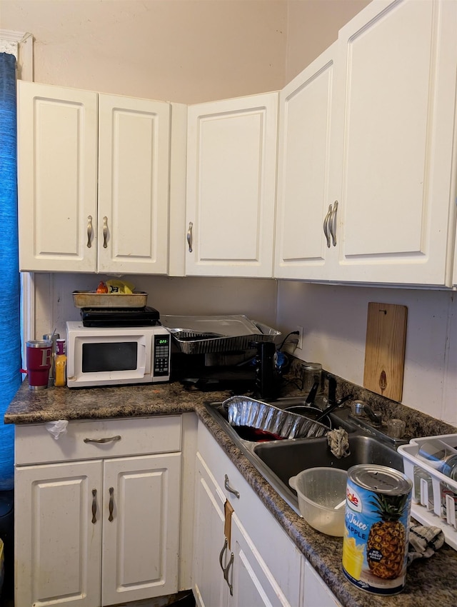 kitchen featuring white cabinetry and sink