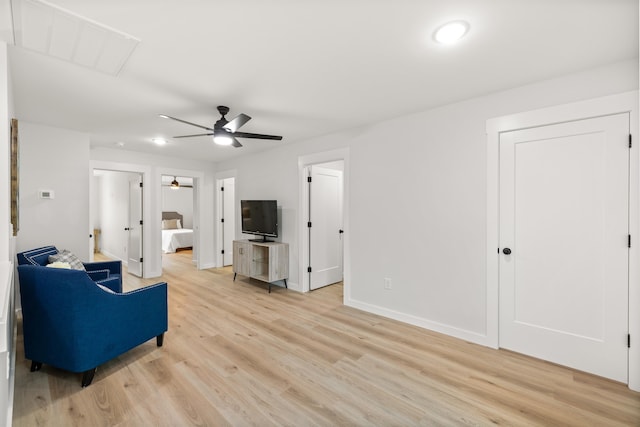 living room featuring ceiling fan and light hardwood / wood-style floors