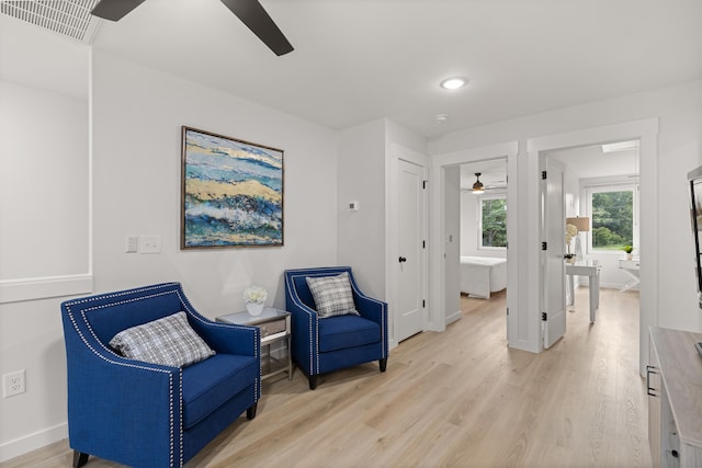 living area featuring ceiling fan and light hardwood / wood-style flooring