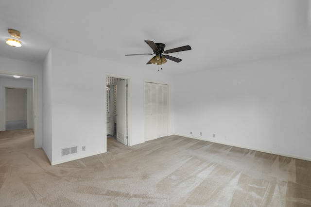 unfurnished bedroom with light colored carpet, ceiling fan, and a closet