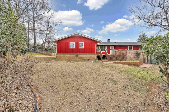 rear view of house with crawl space, a wooden deck, a chimney, and fence