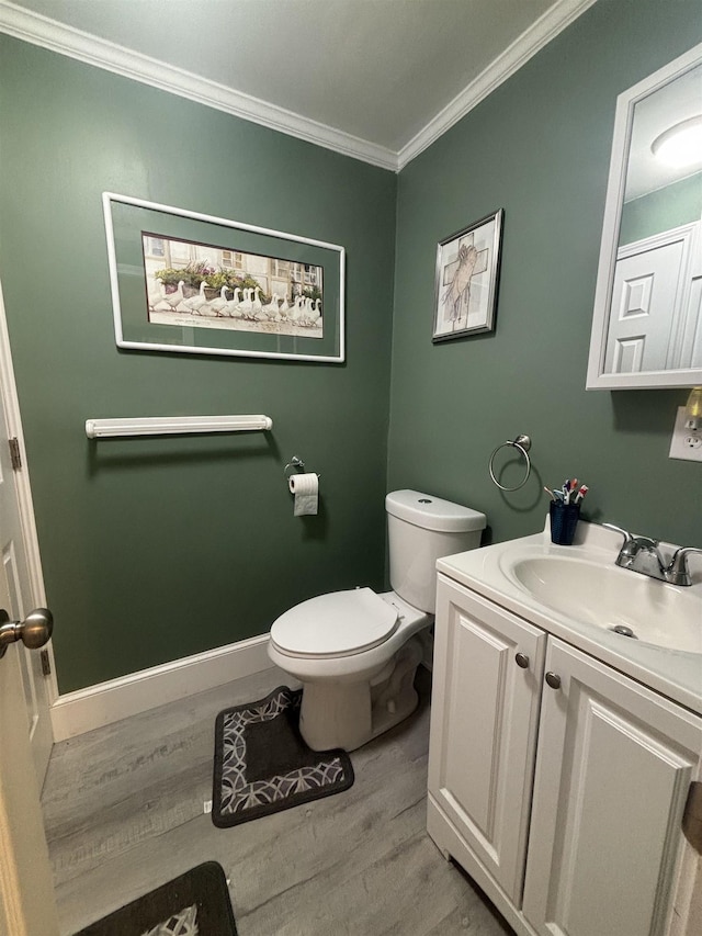 bathroom with crown molding, vanity, toilet, and hardwood / wood-style flooring