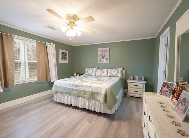 bedroom with ceiling fan, ornamental molding, light hardwood / wood-style floors, and a textured ceiling