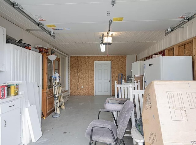 garage with a garage door opener and white refrigerator