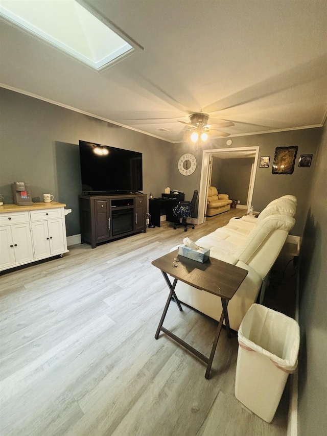 living room featuring crown molding, light hardwood / wood-style flooring, and ceiling fan