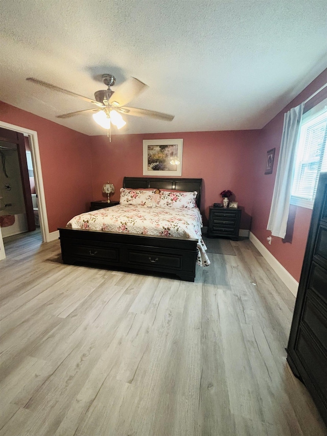 bedroom with ceiling fan, a textured ceiling, and light wood-type flooring