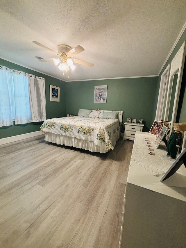 bedroom with ornamental molding, wood-type flooring, ceiling fan, and a textured ceiling