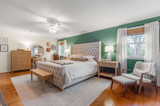 bedroom featuring multiple windows, wood-type flooring, and ornamental molding