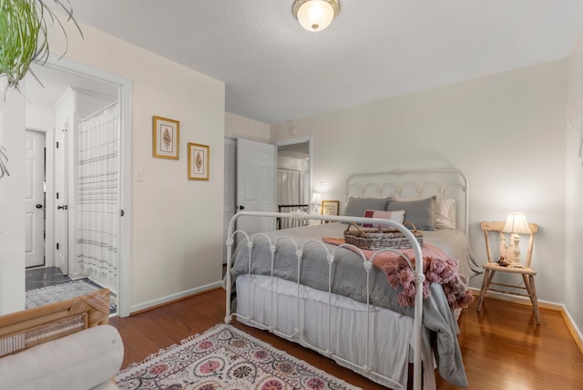 bedroom with hardwood / wood-style floors and a textured ceiling