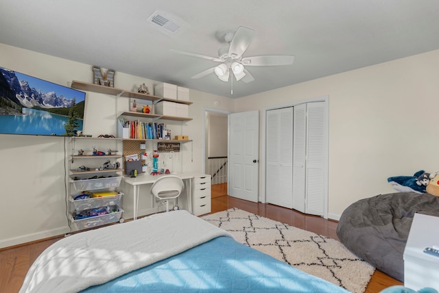 bedroom with dark wood-type flooring, ceiling fan, and a closet