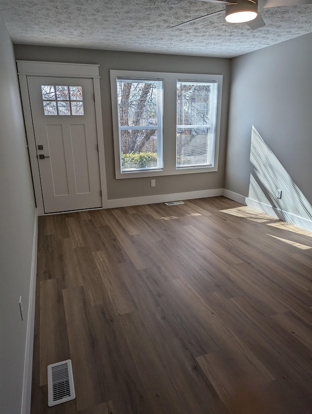 foyer with dark hardwood / wood-style flooring and a textured ceiling