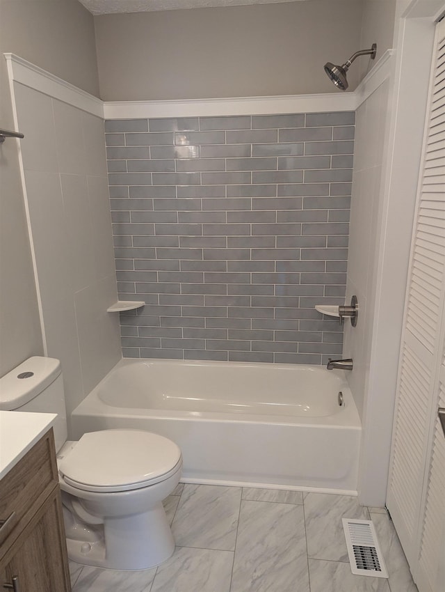 full bathroom with vanity, tiled shower / bath, and toilet