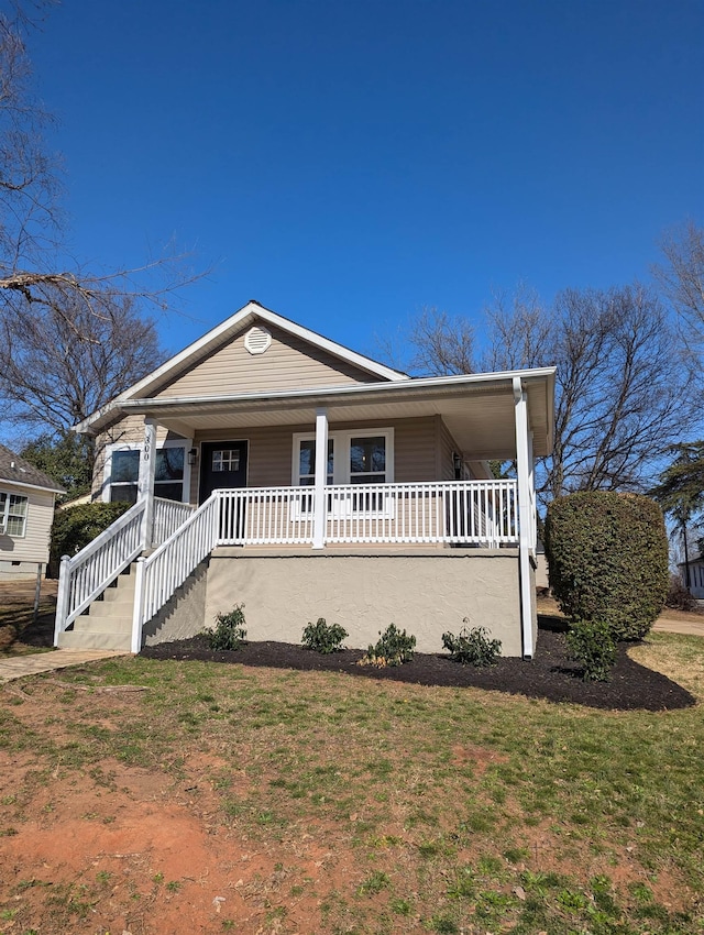 view of front of home featuring covered porch and a front yard