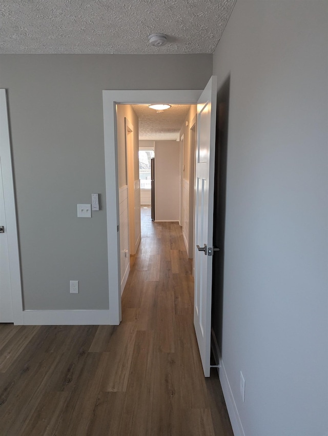 corridor featuring hardwood / wood-style flooring and a textured ceiling