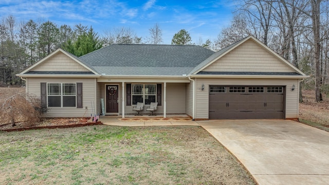 view of front of property featuring a garage, a front yard, and a porch