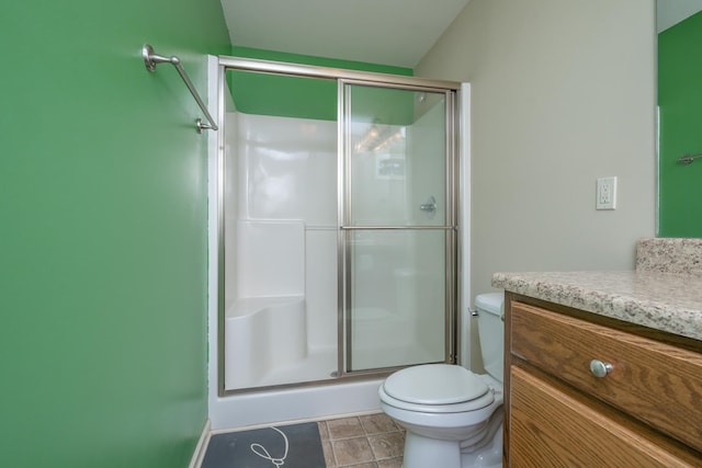 bathroom with vanity, toilet, an enclosed shower, and tile patterned flooring