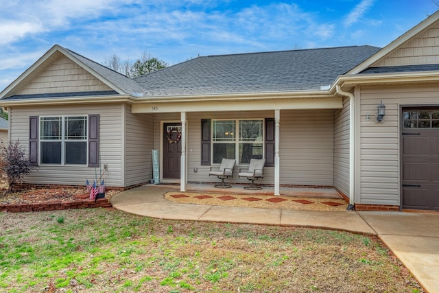 view of front of property featuring a garage, a front lawn, and a porch