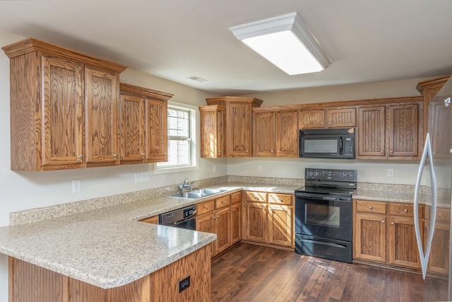 kitchen featuring dark hardwood / wood-style flooring, kitchen peninsula, sink, and black appliances