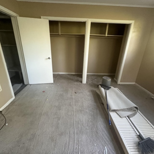 unfurnished bedroom featuring two closets and ornamental molding