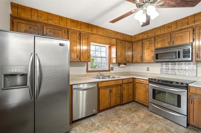 kitchen featuring ceiling fan, stainless steel appliances, sink, and a textured ceiling