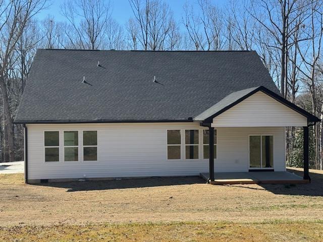 rear view of property with a yard and a patio area