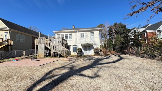 back of property with an outdoor fire pit and a patio