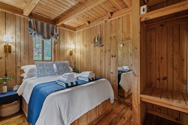 bedroom featuring beamed ceiling, hardwood / wood-style floors, wooden ceiling, and wood walls