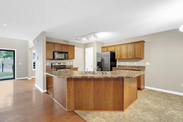 kitchen featuring appliances with stainless steel finishes, sink, a kitchen island with sink, and rail lighting