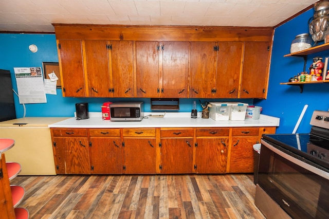 kitchen with hardwood / wood-style flooring and appliances with stainless steel finishes