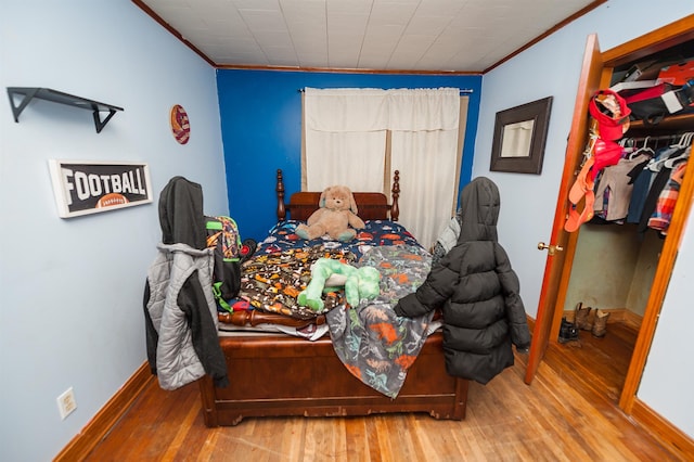 bedroom featuring hardwood / wood-style floors and ornamental molding