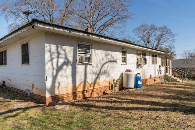 view of side of property featuring cooling unit and a yard