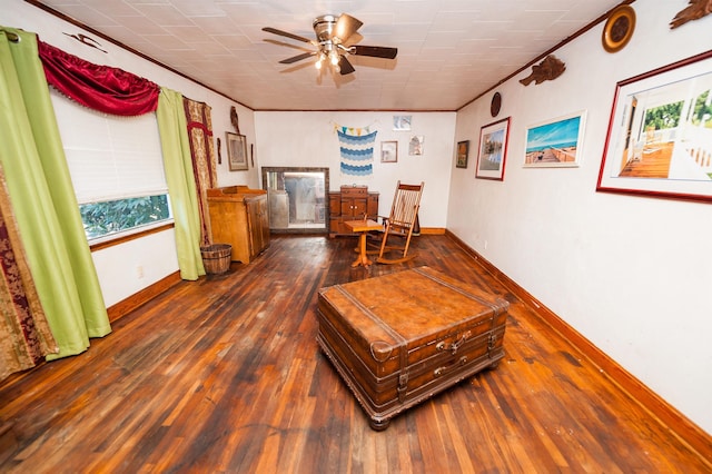 living area featuring dark hardwood / wood-style flooring, ceiling fan, crown molding, and a healthy amount of sunlight