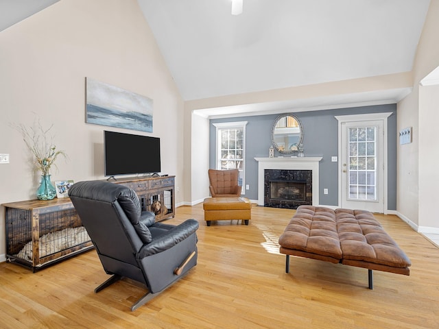 living room with high vaulted ceiling, a healthy amount of sunlight, a fireplace, and hardwood / wood-style floors