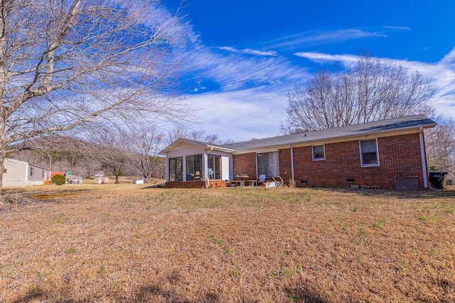 rear view of property featuring a yard and a sunroom