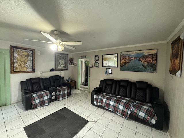 living room with ceiling fan, ornamental molding, light tile patterned floors, and a textured ceiling