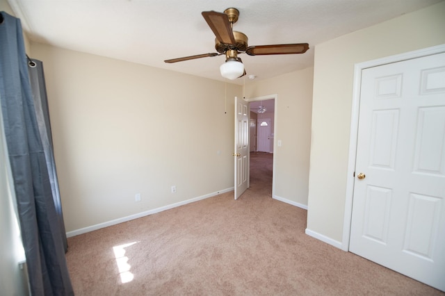 unfurnished bedroom with light colored carpet and ceiling fan