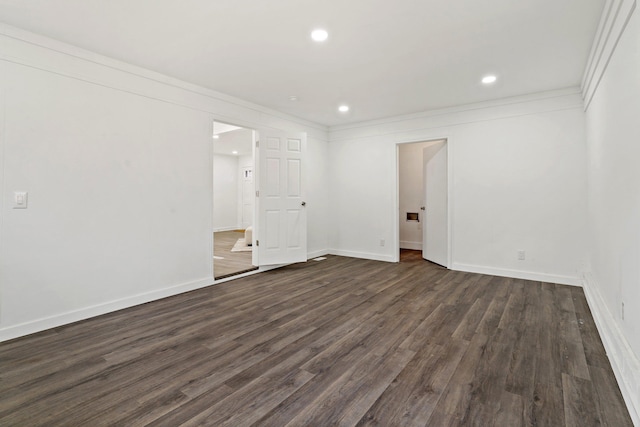 spare room featuring ornamental molding and dark wood-type flooring