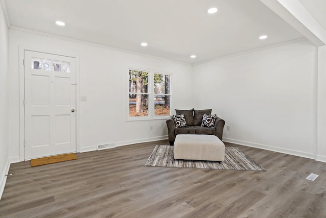 living area with hardwood / wood-style floors and crown molding