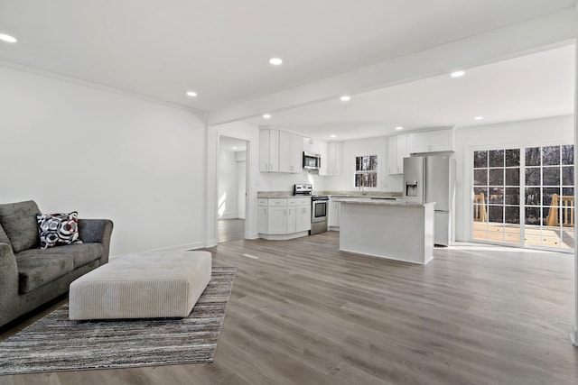 living room with light wood-type flooring and beam ceiling