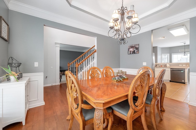 dining room featuring an inviting chandelier, a tray ceiling, and ornamental molding